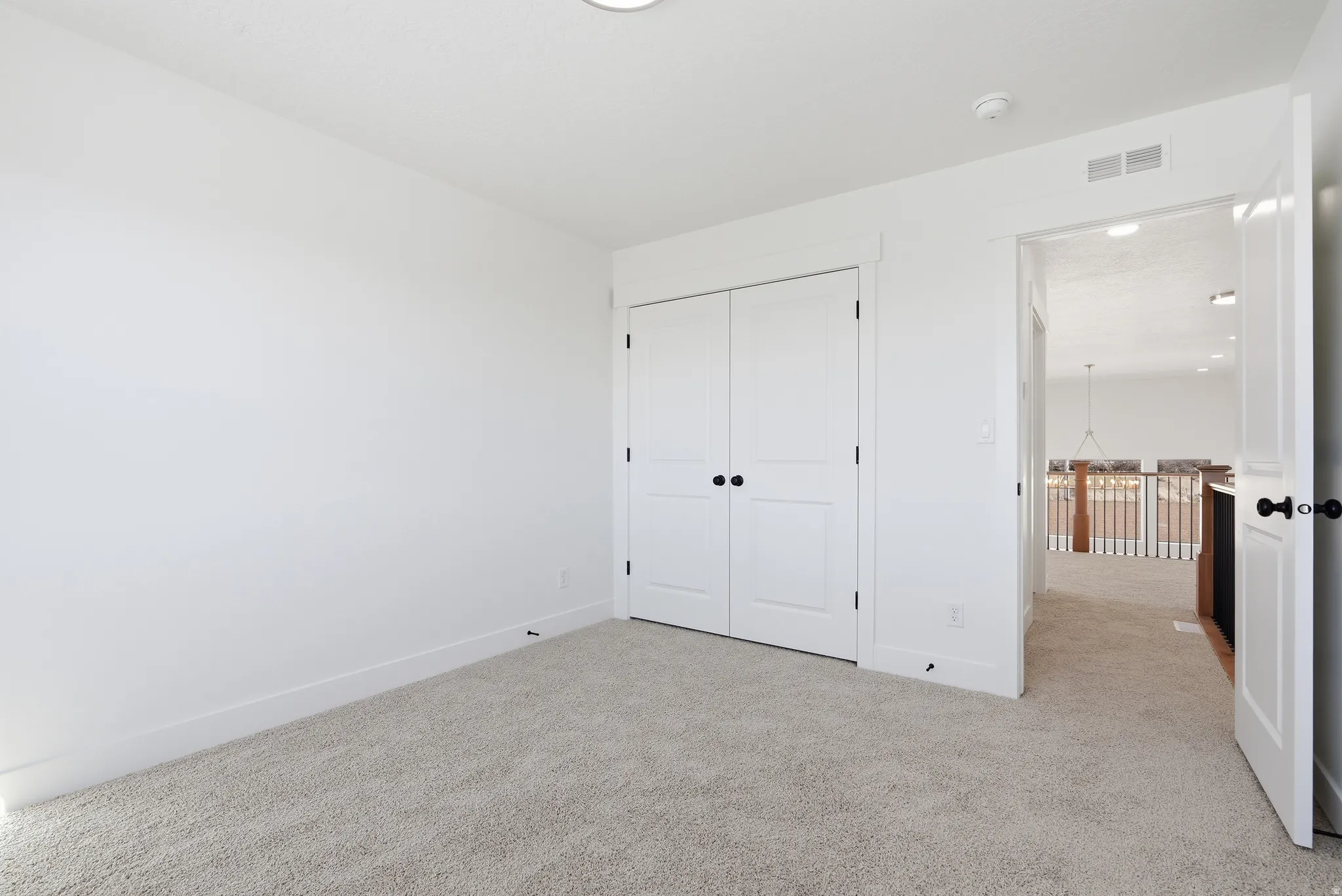 Unfurnished bedroom with light carpet and a closet