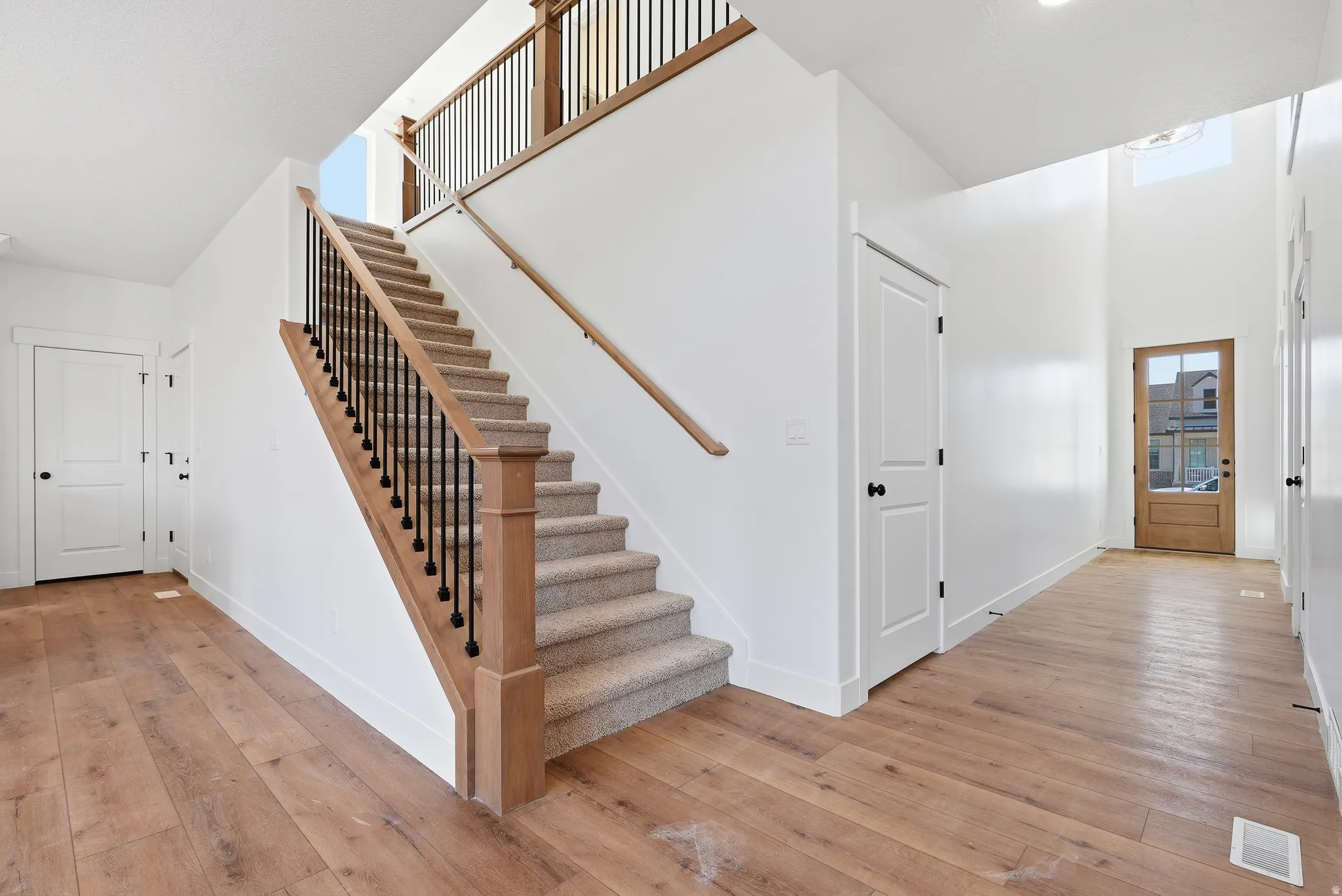 Stairway featuring hardwood / wood-style flooring and a high ceiling
