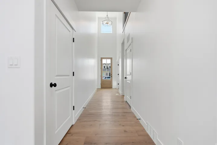 Hallway featuring a high ceiling and light wood-type flooring