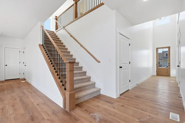Stairway featuring hardwood / wood-style flooring and a high ceiling