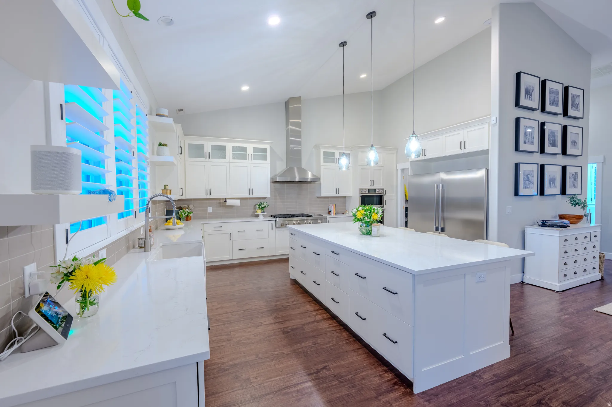 Kitchen featuring vaulted ceiling, white cabinets, a center island, tasteful backsplash, and light stone counters