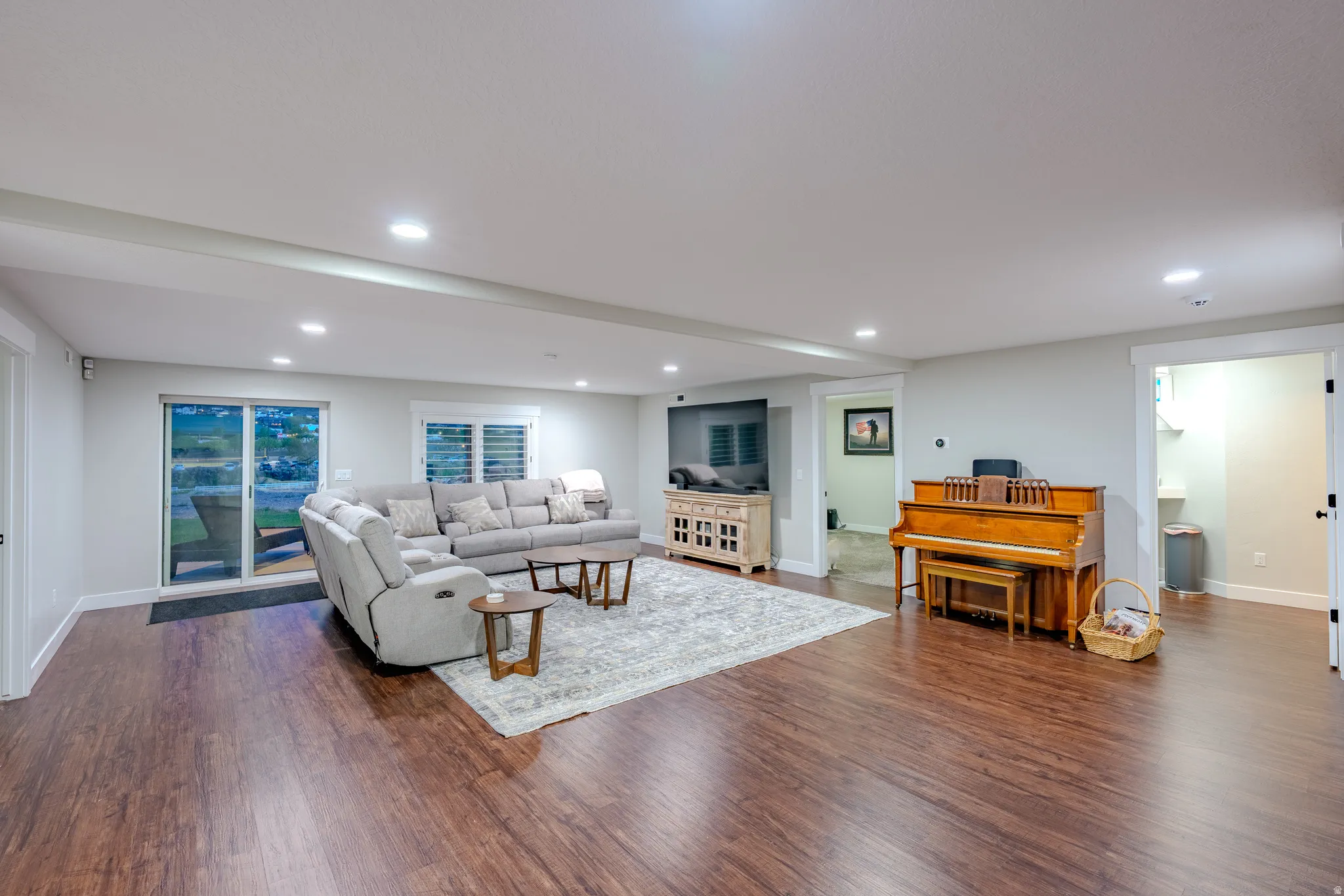 Living area with dark wood-type flooring and recessed lighting