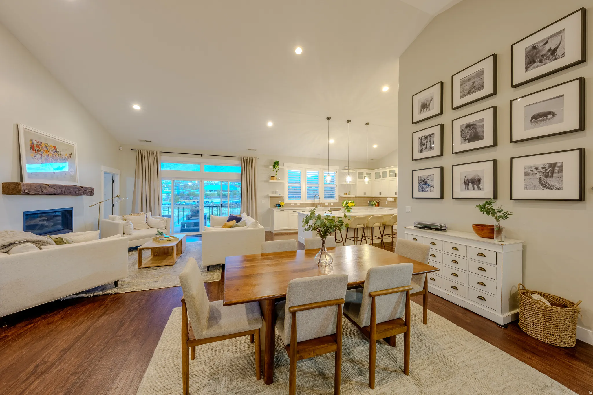 Dining space featuring lofted ceiling, light wood-style floors, a glass covered fireplace, and recessed lighting
