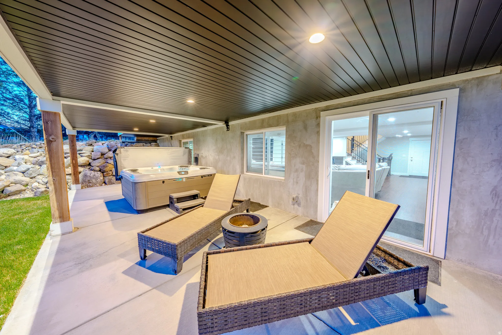 View of patio / terrace with a hot tub and an outdoor fire pit