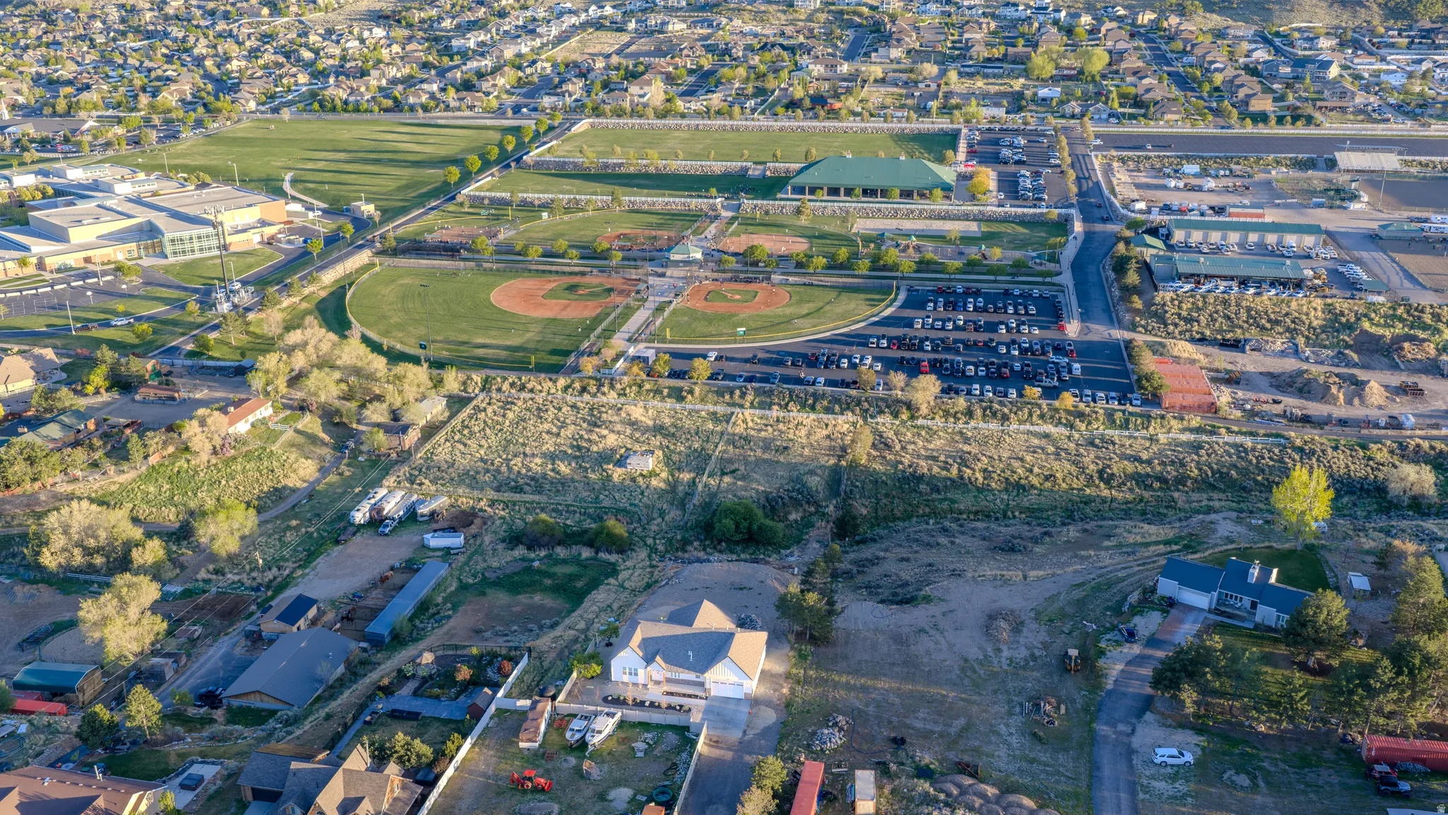 Aerial view of property and surrounding area featuring nearby suburban area