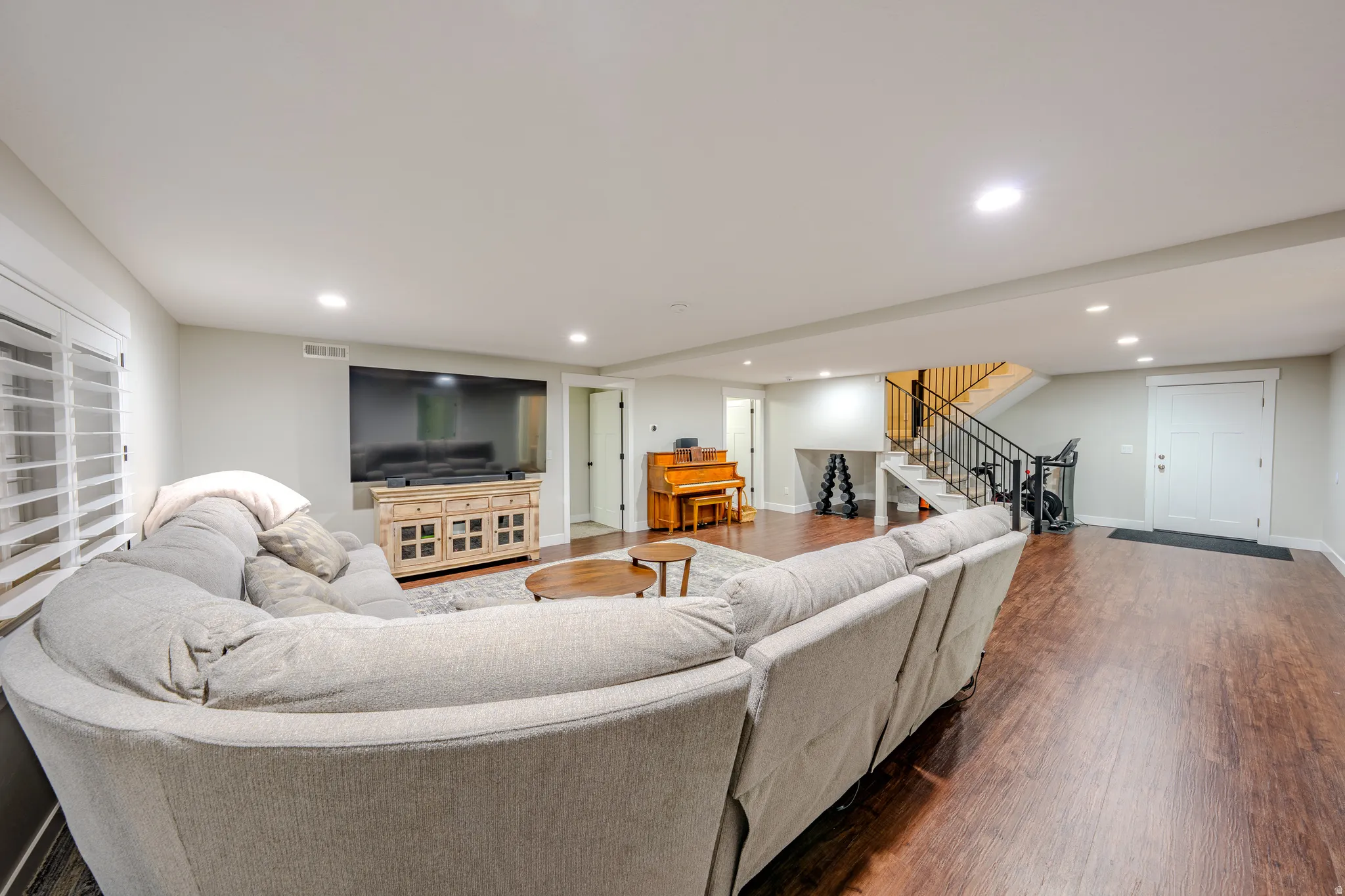 Living room with dark wood finished floors and recessed lighting