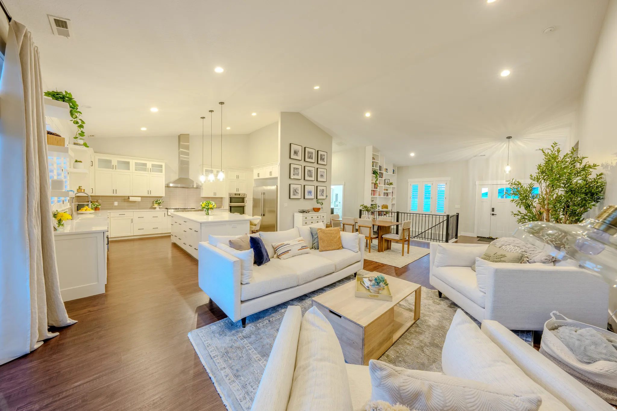 Living room featuring lofted ceiling, dark wood finished floors, and hanging lights