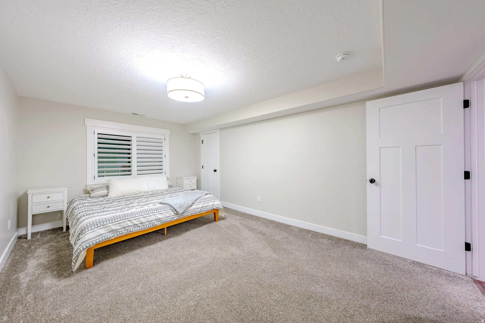 Bedroom with light carpet and a textured ceiling