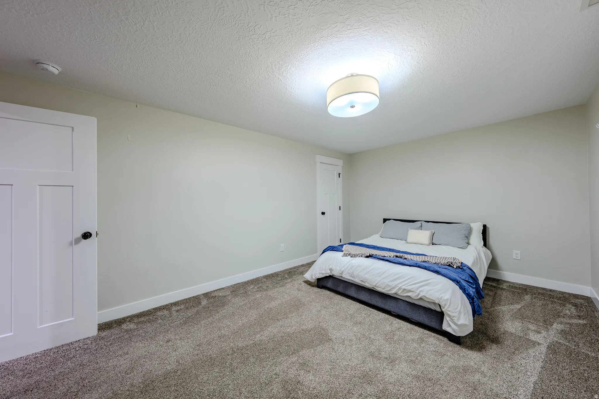 Bedroom featuring carpet and a textured ceiling