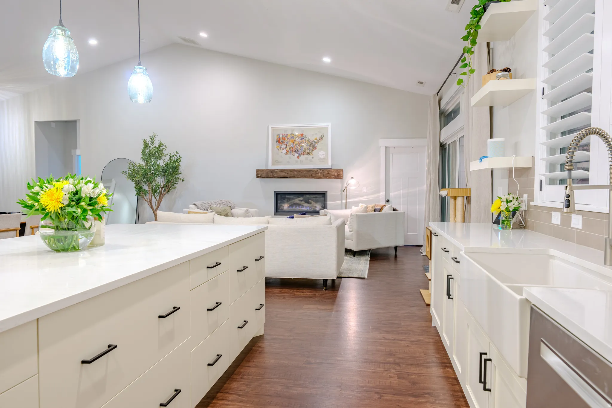 Kitchen with stainless steel dishwasher, open floor plan, light stone countertops, dark wood finished floors, and lofted ceiling