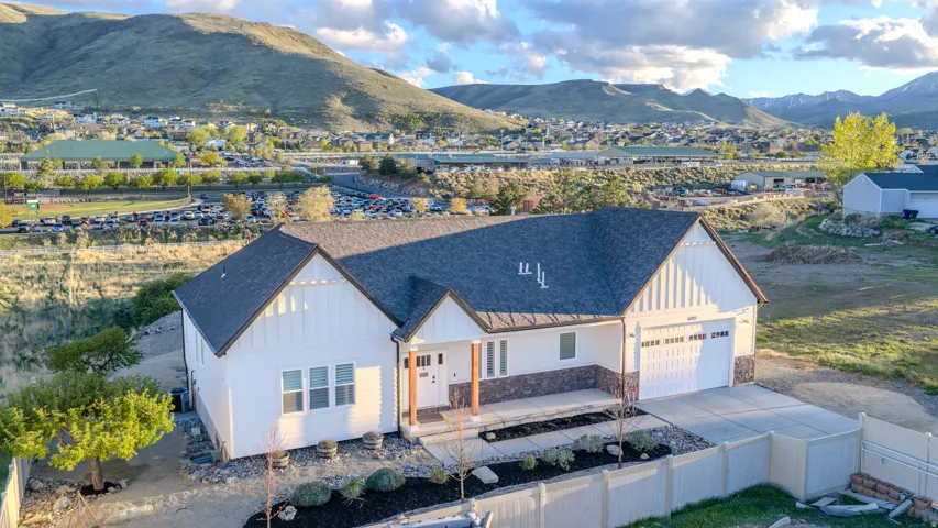 Modern inspired farmhouse with a porch, roof with shingles, a mountain view, board and batten siding, and driveway