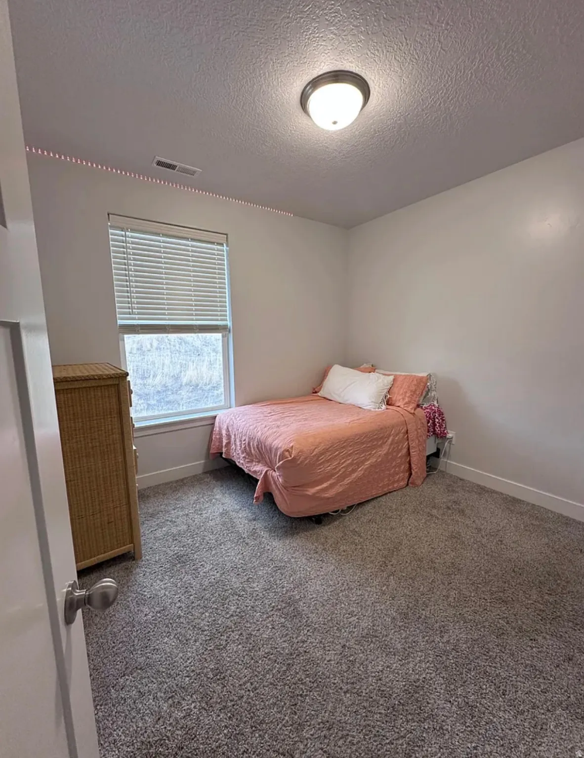 Bedroom featuring a textured ceiling and carpet