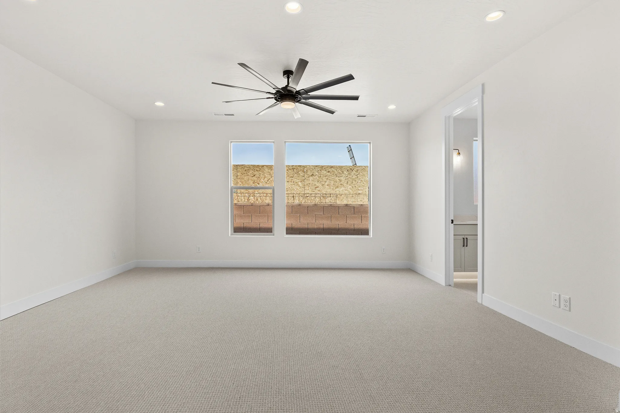 Unfurnished room featuring light carpet, a ceiling fan, and recessed lighting