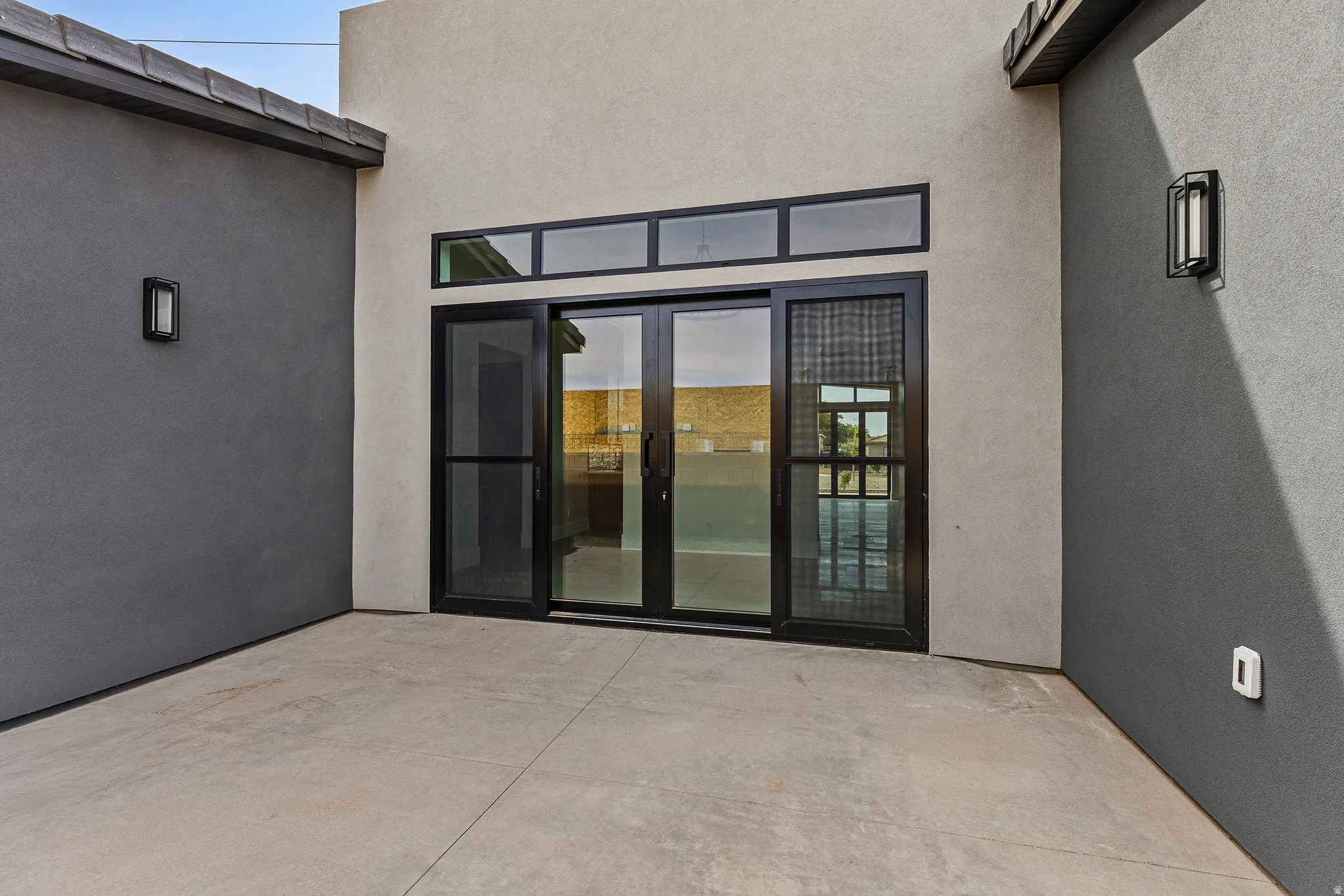 Doorway to property with french doors, stucco siding, and a patio