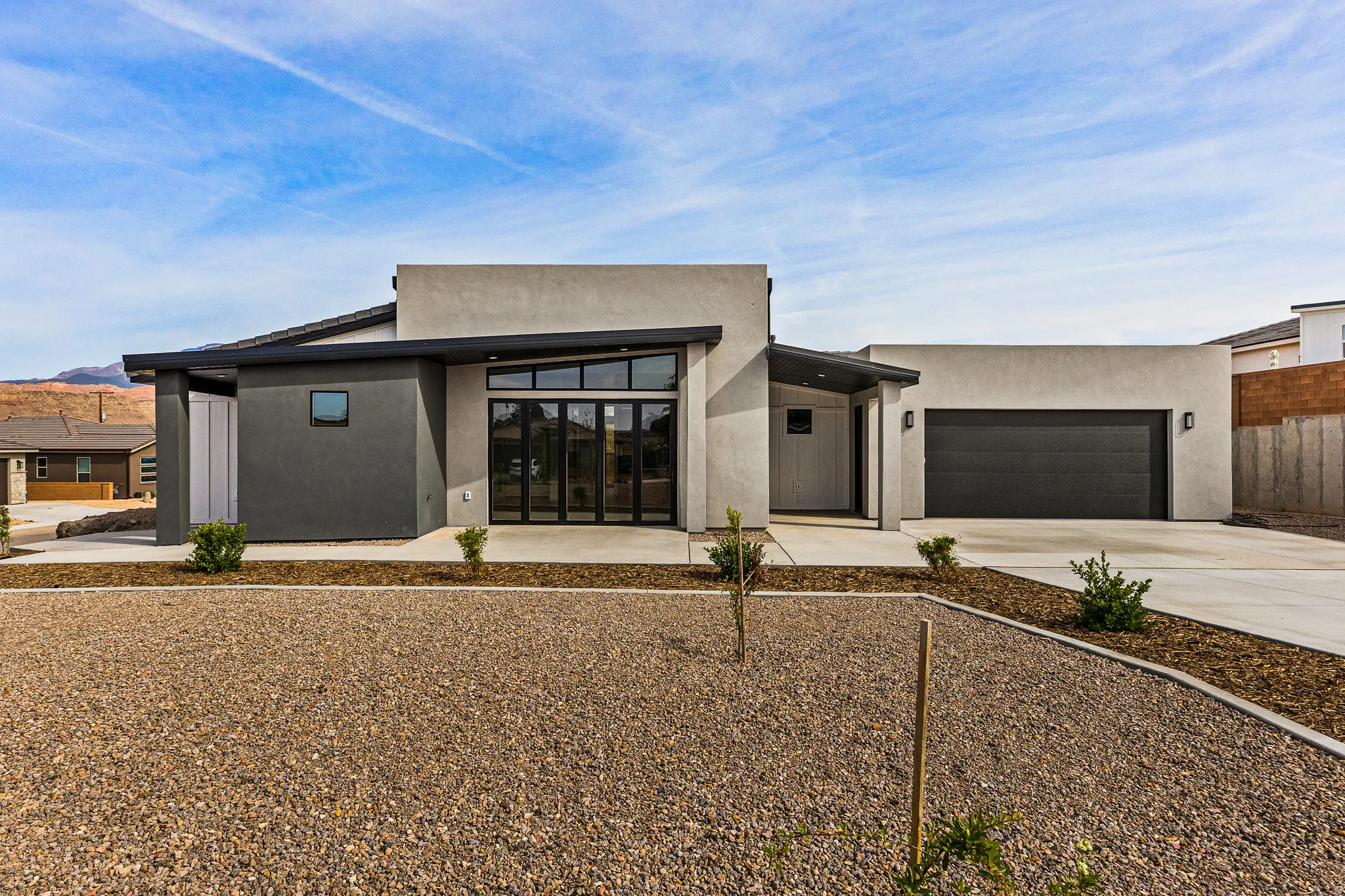 Modern home featuring driveway, a garage, and stucco siding