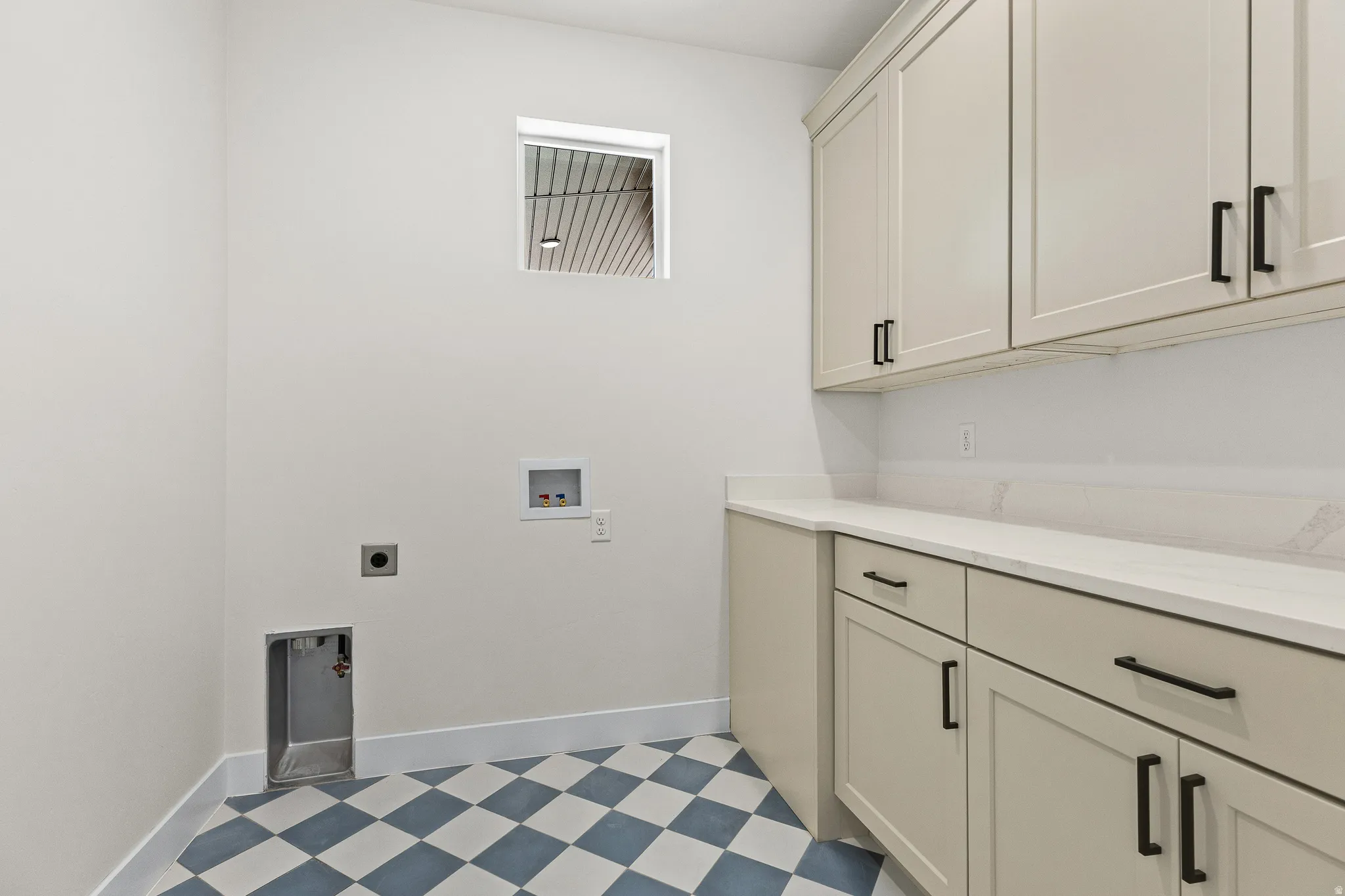 Laundry room with light floors, washer hookup, cabinet space, and electric dryer hookup