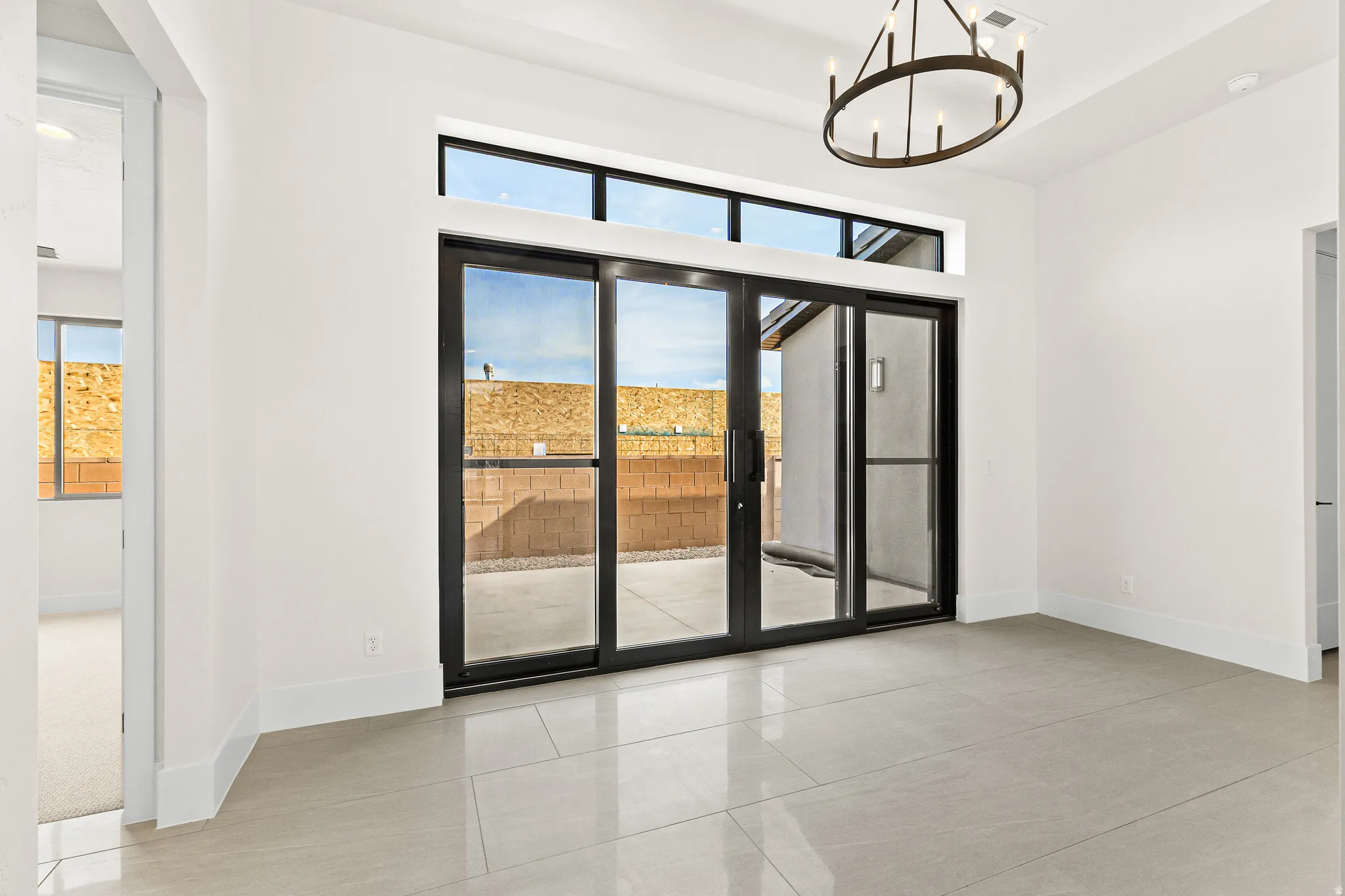 Unfurnished room featuring healthy amount of natural light, suspended lighting, and light tile patterned floors