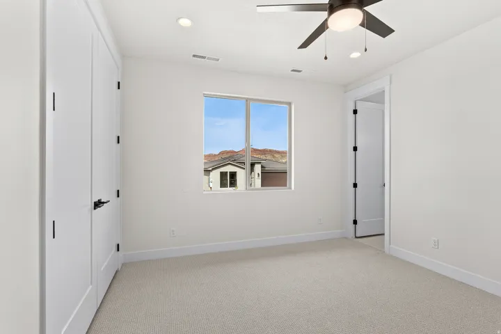 Unfurnished bedroom with light carpet, recessed lighting, ceiling fan, and multiple closets