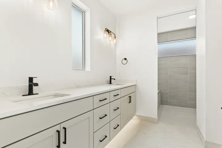 Full bathroom featuring double vanity and a walk in shower