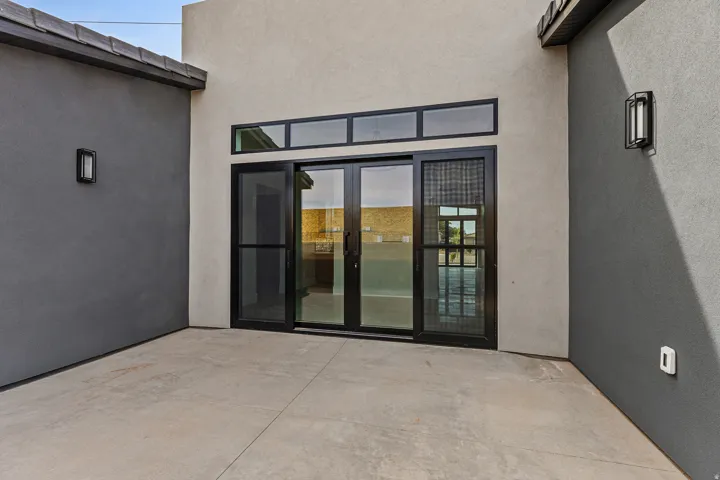 Doorway to property with french doors, stucco siding, and a patio
