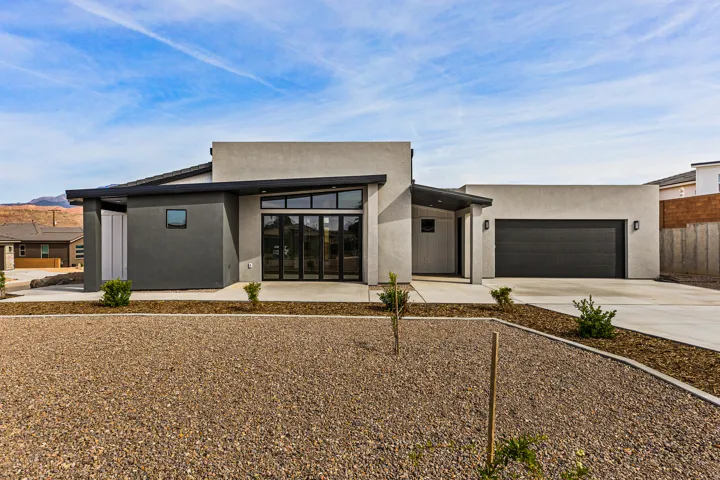 Modern home featuring driveway, a garage, and stucco siding