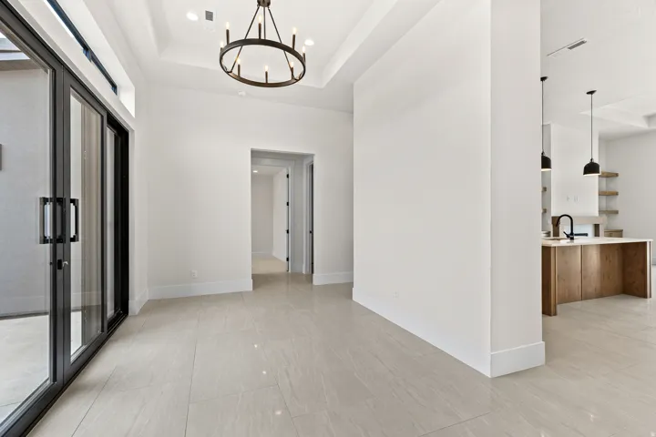 Corridor with hanging lights and a tray ceiling
