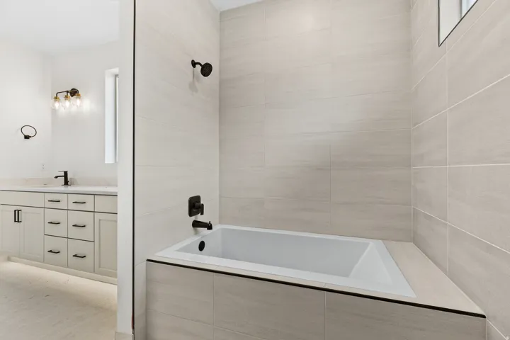 Bathroom featuring tiled shower / bath and vanity