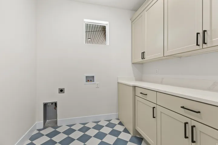 Laundry room with light floors, washer hookup, cabinet space, and electric dryer hookup
