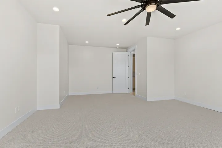 Spare room with light colored carpet, ceiling fan, and recessed lighting