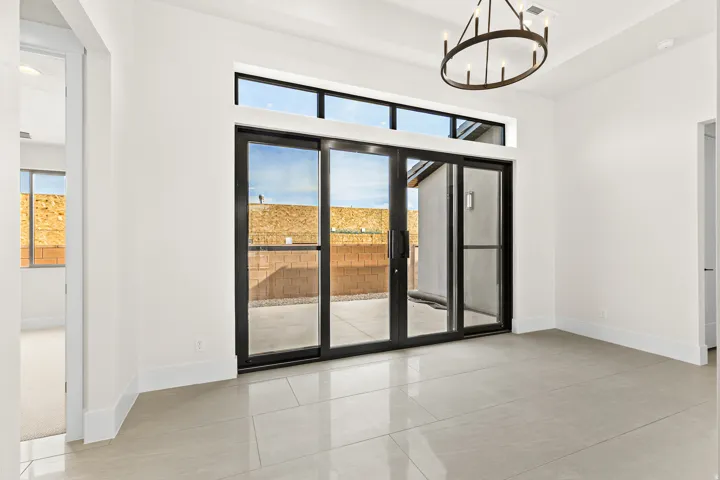 Unfurnished room featuring healthy amount of natural light, suspended lighting, and light tile patterned floors