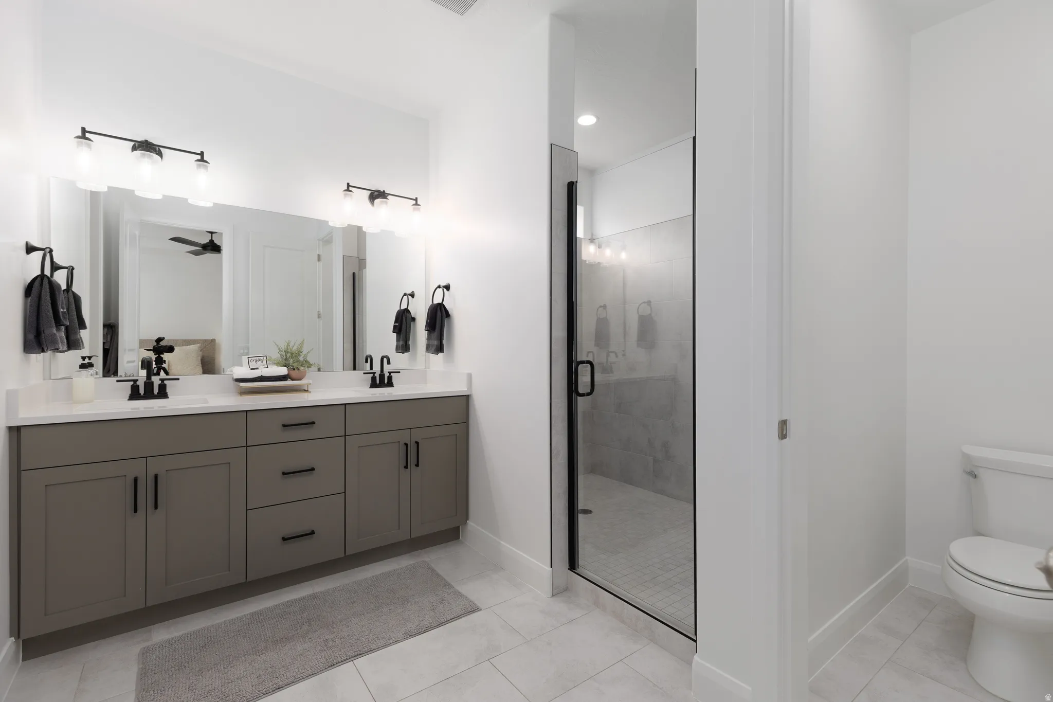 Full bathroom with double vanity, a stall shower, recessed lighting, and ceiling fan