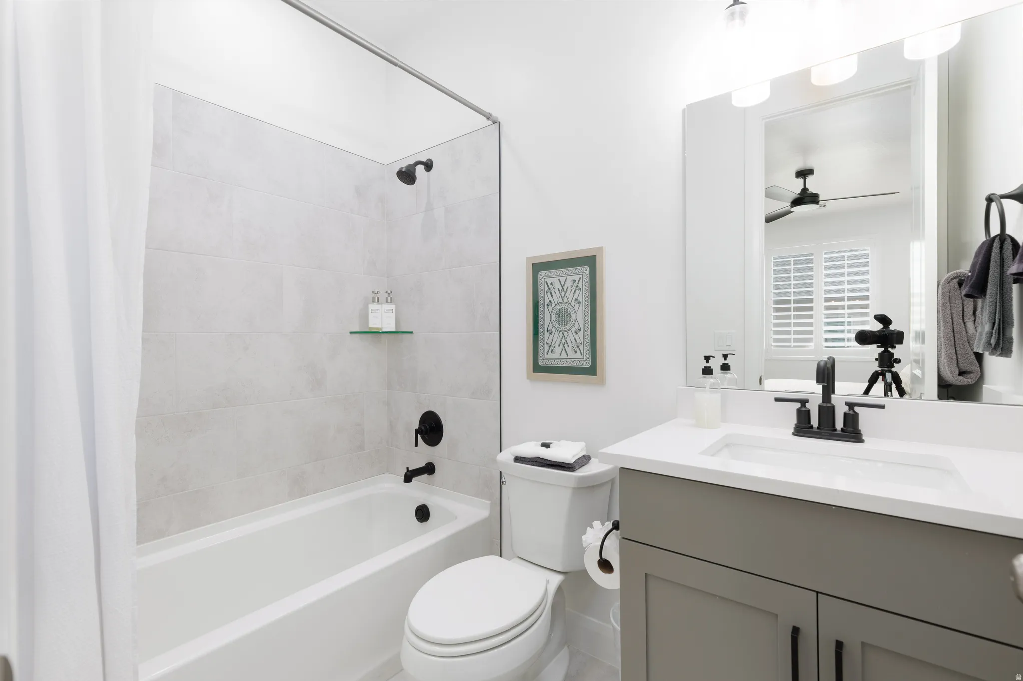 Bathroom with vanity, shower / bath combo, and a ceiling fan