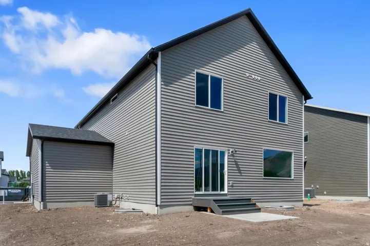 Gray horizontal siding exterior with a black shingle roof, dark trim, and multiple windows