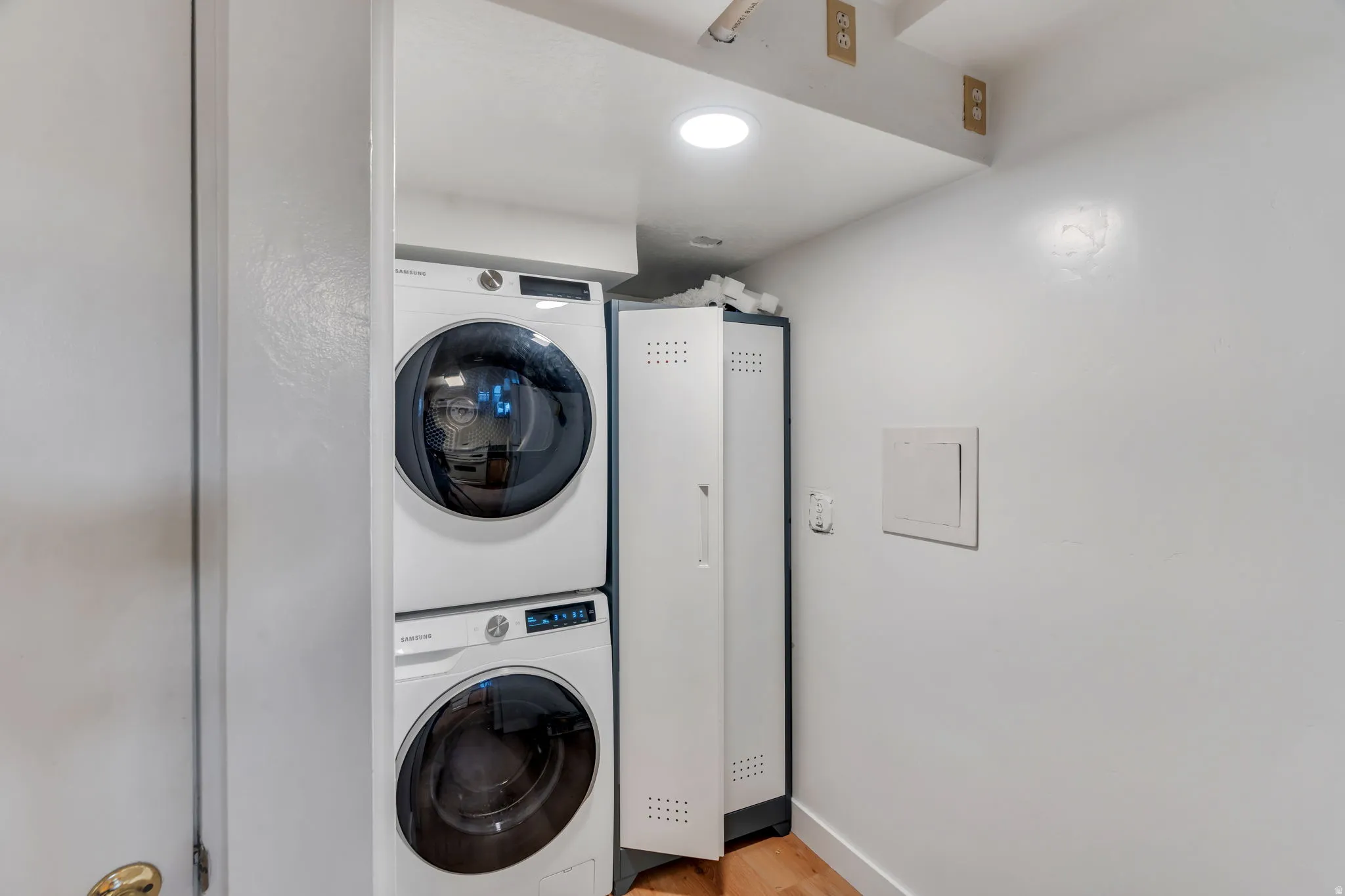 Laundry area featuring stacked washer and clothes dryer and recessed lighting