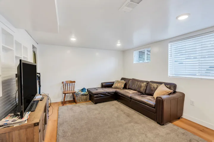 Living room with light wood-style flooring and recessed lighting