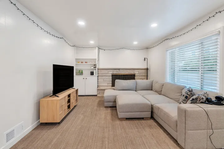 Spacious living room has laminate flooring and a stone fireplace