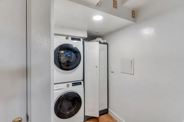 Laundry area featuring stacked washer and clothes dryer and recessed lighting