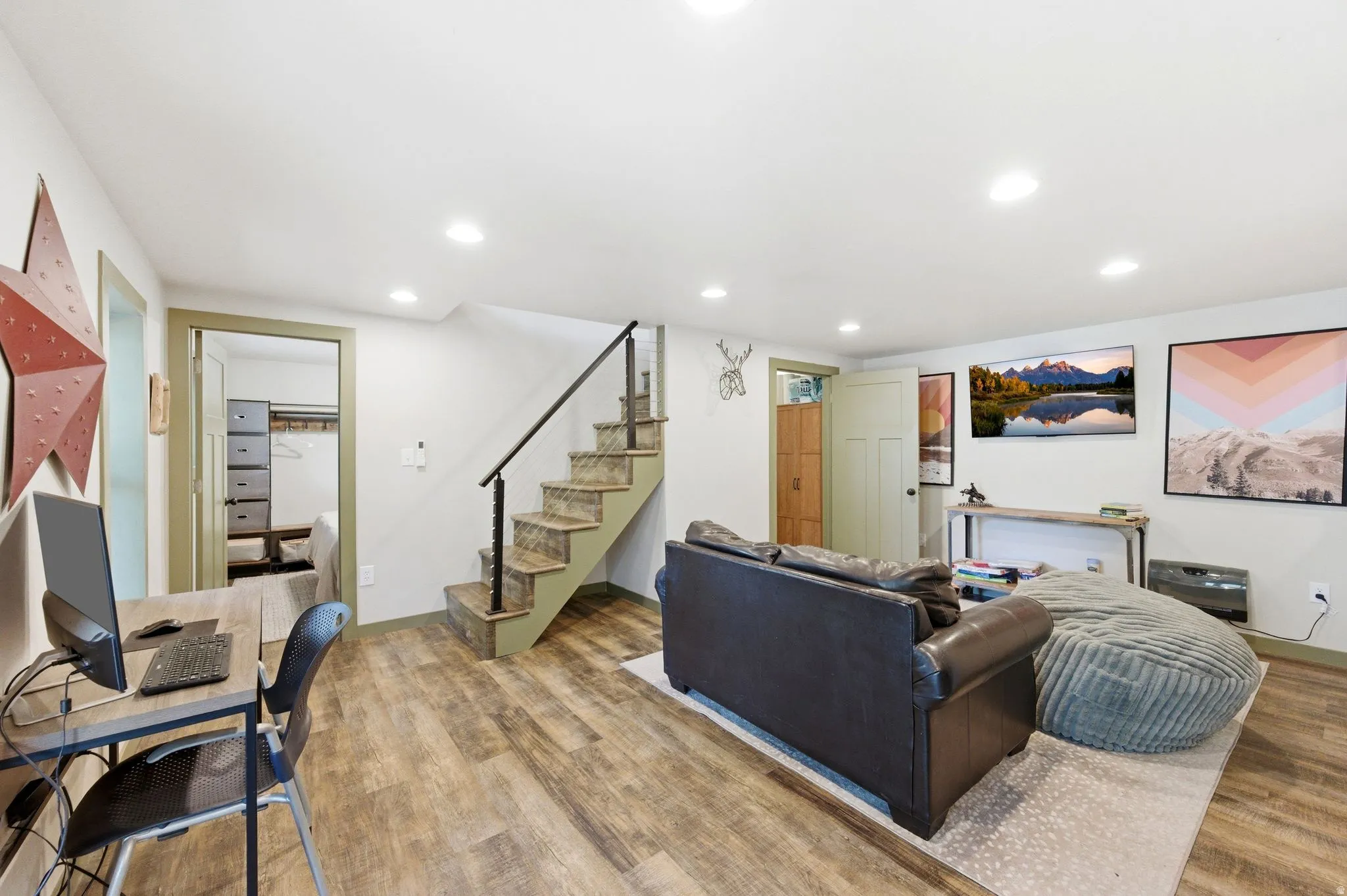Downstairs living room with french doors, LVP floors, sleeping nook, wood or coal burning stove and recessed lighting