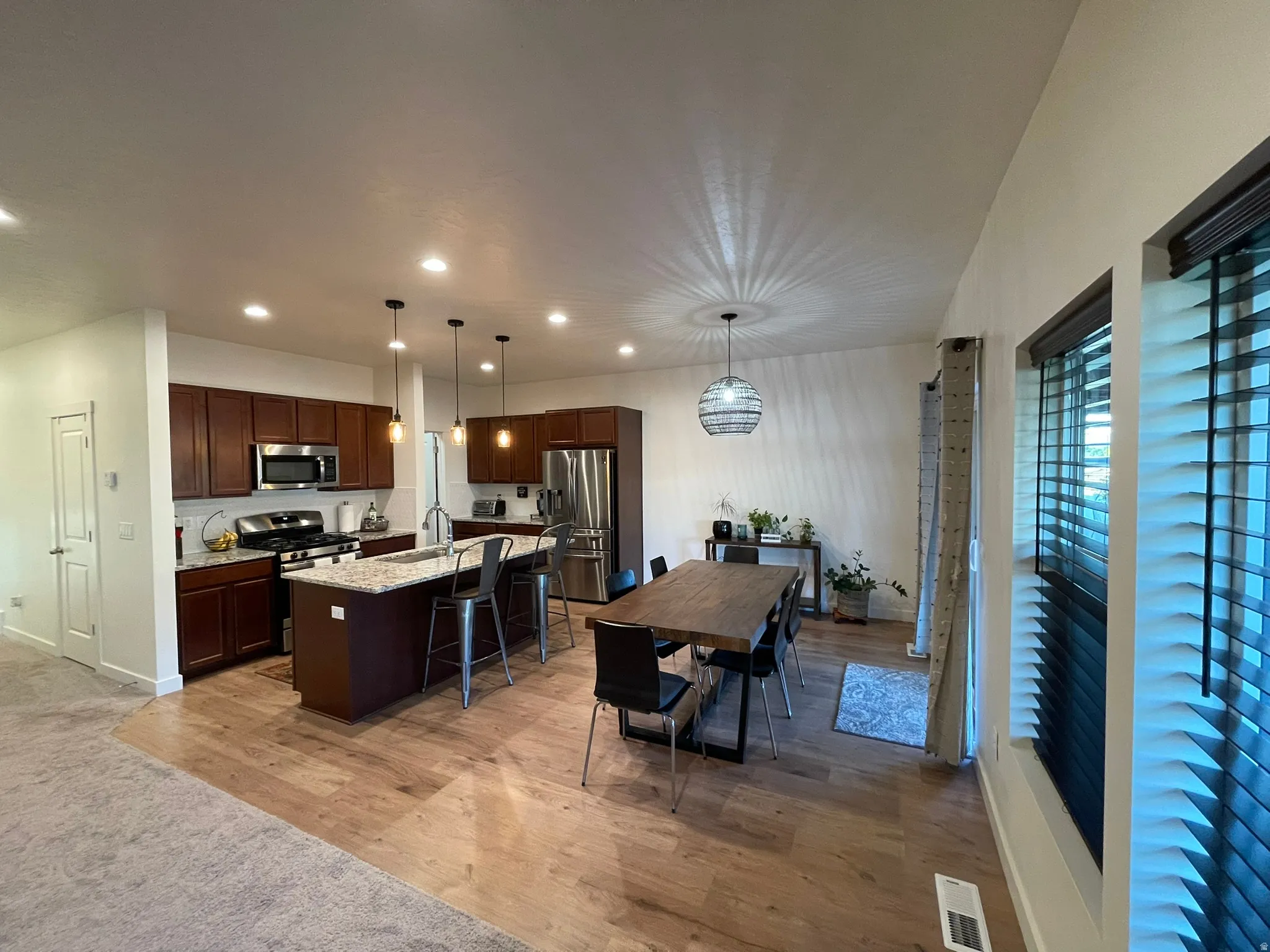 Dining area with light wood-type flooring and recessed lighting