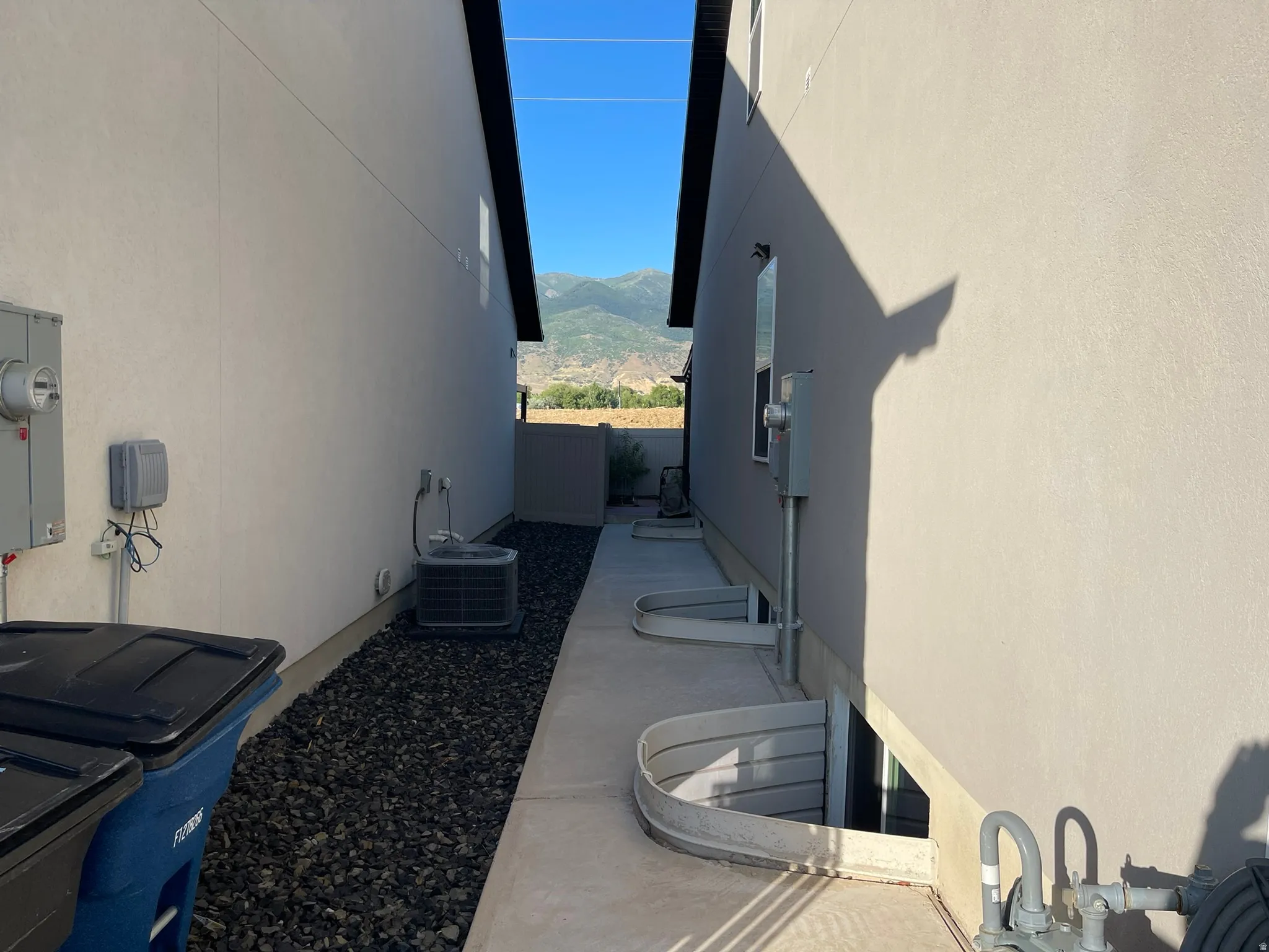 View of home's exterior with stucco siding, a mountain view, and a patio area