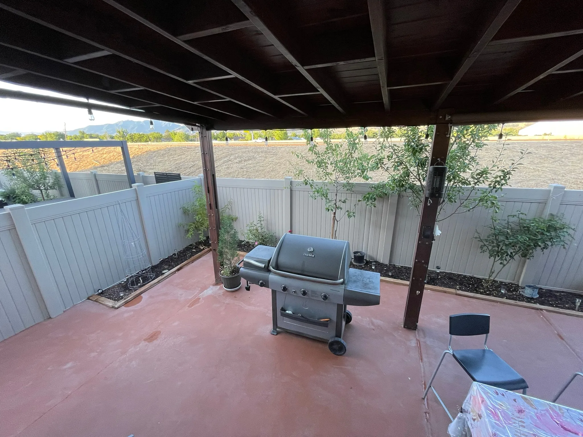 Fenced backyard with grilling area, a patio, and a mountain view