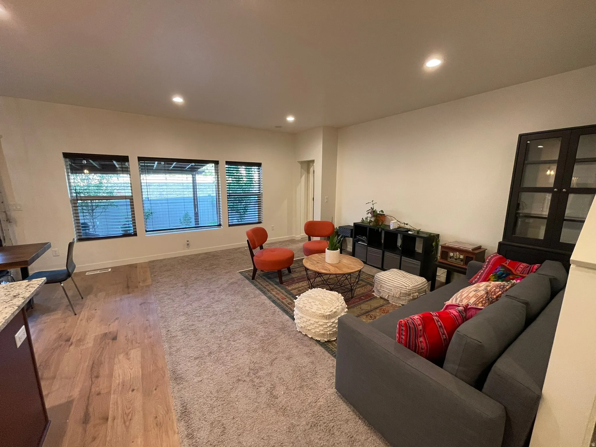 Living area with light wood-style floors and recessed lighting