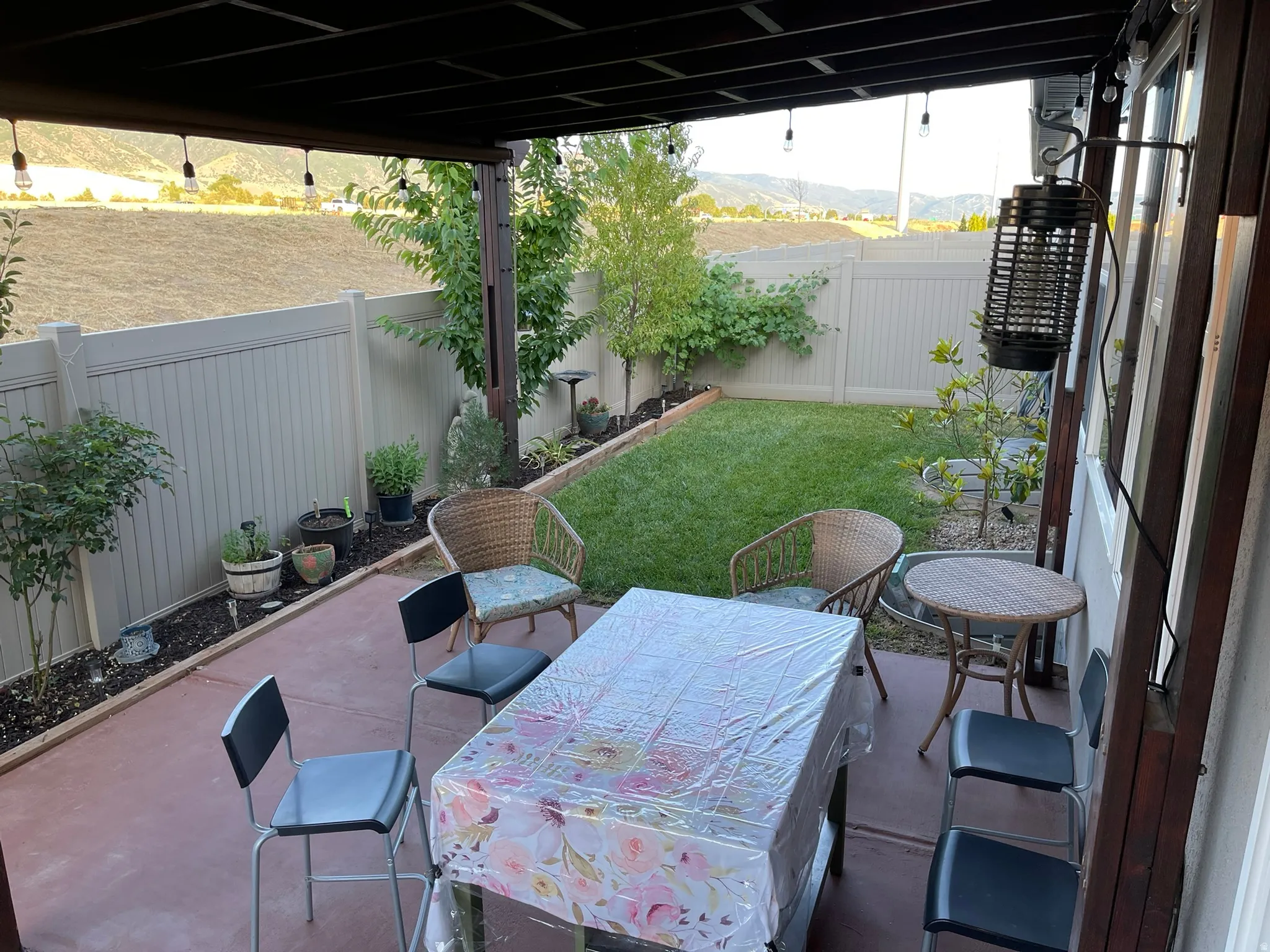 Fenced backyard with a patio, outdoor dining space, and a mountain view