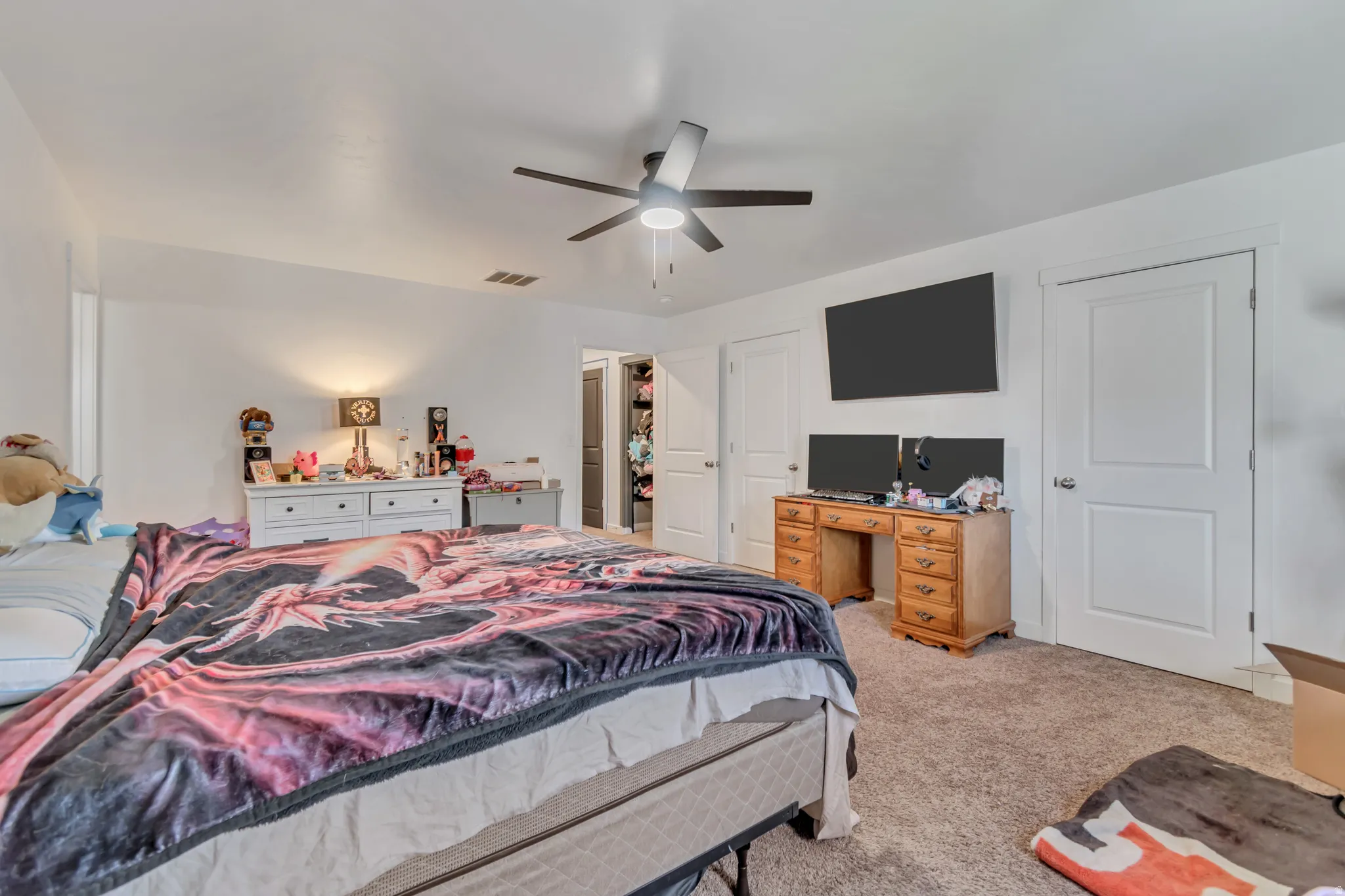 Bedroom with light colored carpet and a ceiling fan