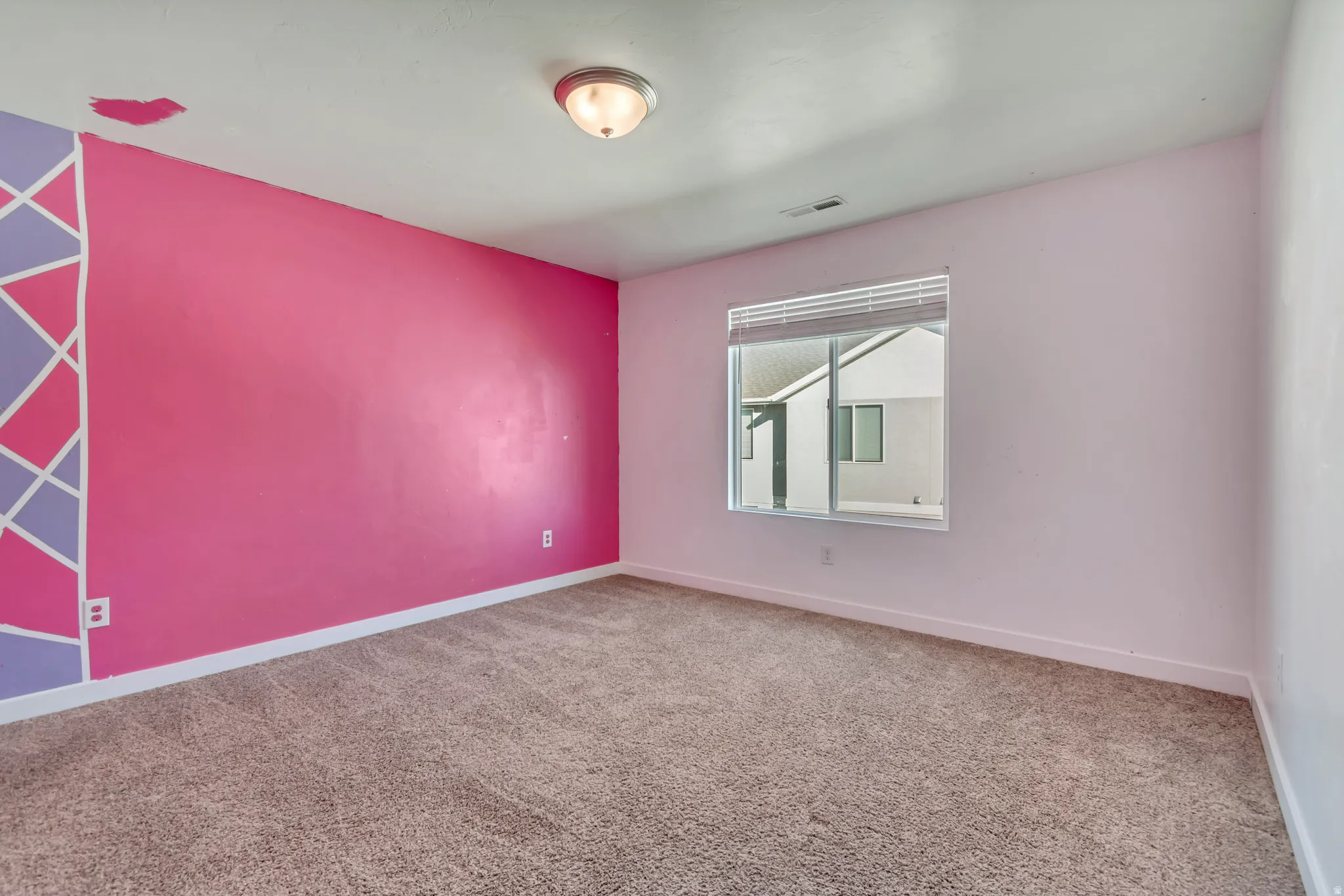 Carpeted spare room with baseboards and an accent wall