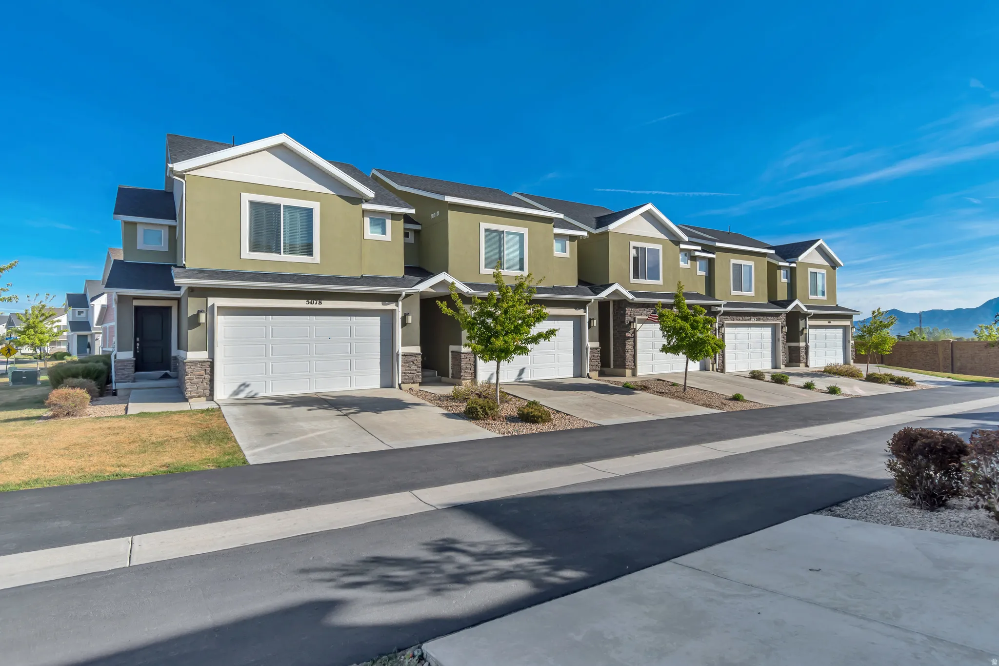 View of front of home with stucco siding, a mountain view, an attached garage, and driveway