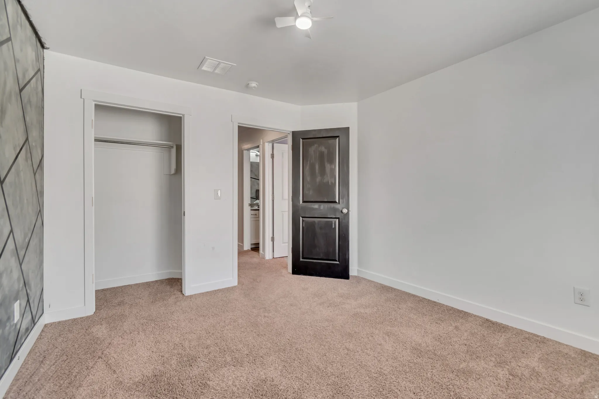 Unfurnished bedroom featuring light colored carpet and a closet