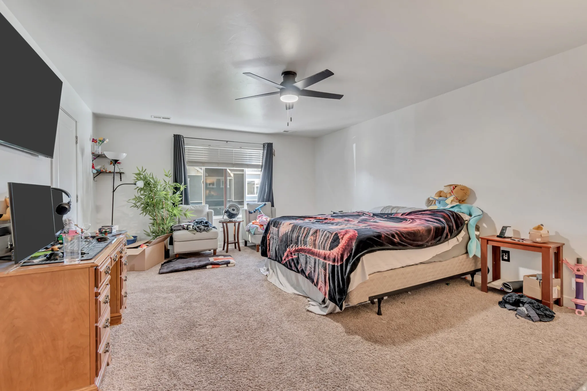 Bedroom with light carpet and a ceiling fan