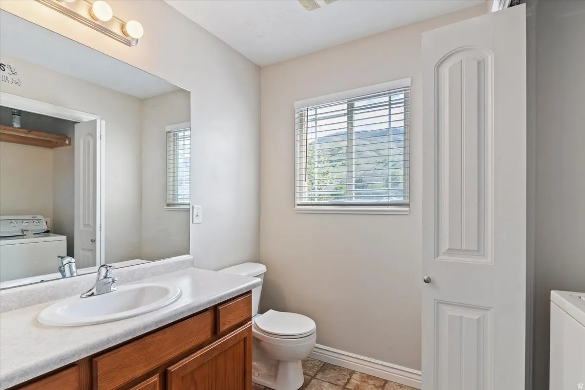 Half bathroom with vanity and washer / dryer