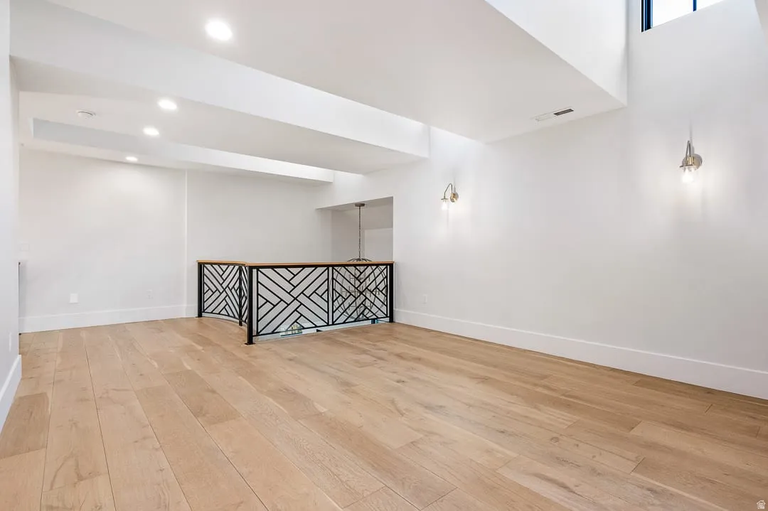 Empty room featuring light wood-style floors, a dry bar, and recessed lighting